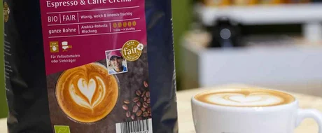 Eine Tasse Cappuchino, neben dieser steht eine Kaffeeverpackung von GEPO.